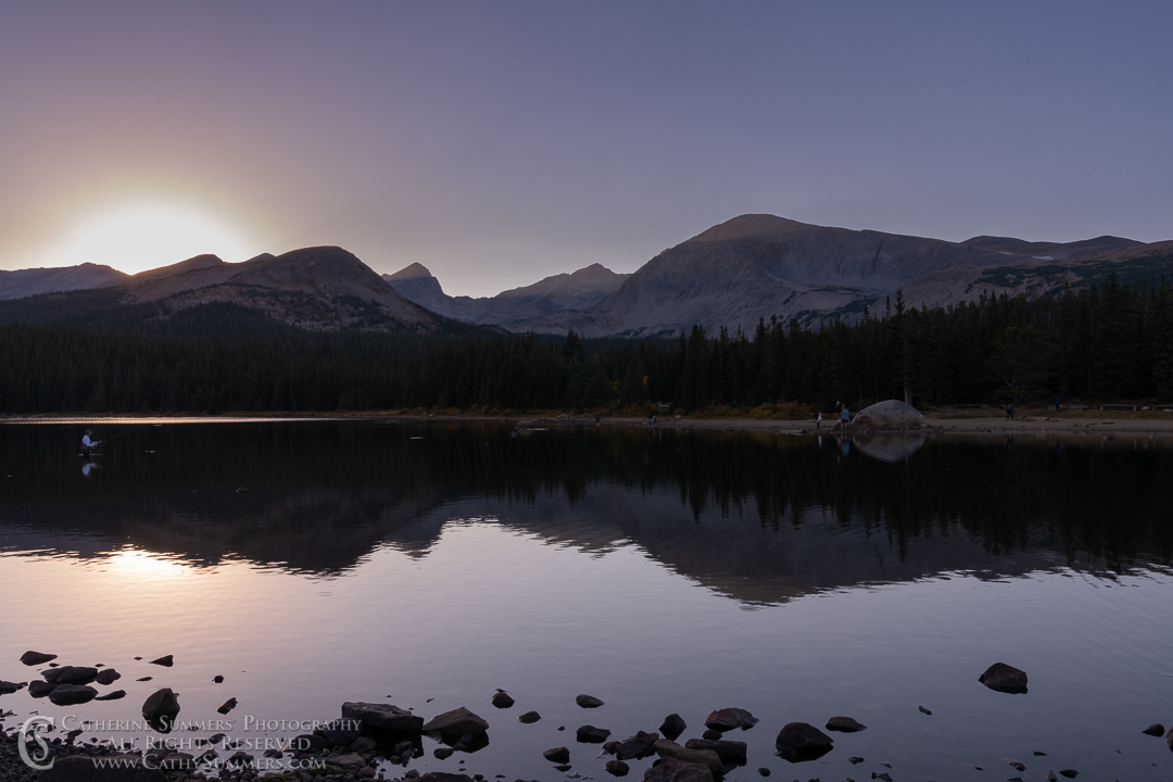 Fisherman in Braninbridge Lake at Sunset on an Autumn Afternoon with Reflection of Mount Audubon and Indian Peaks