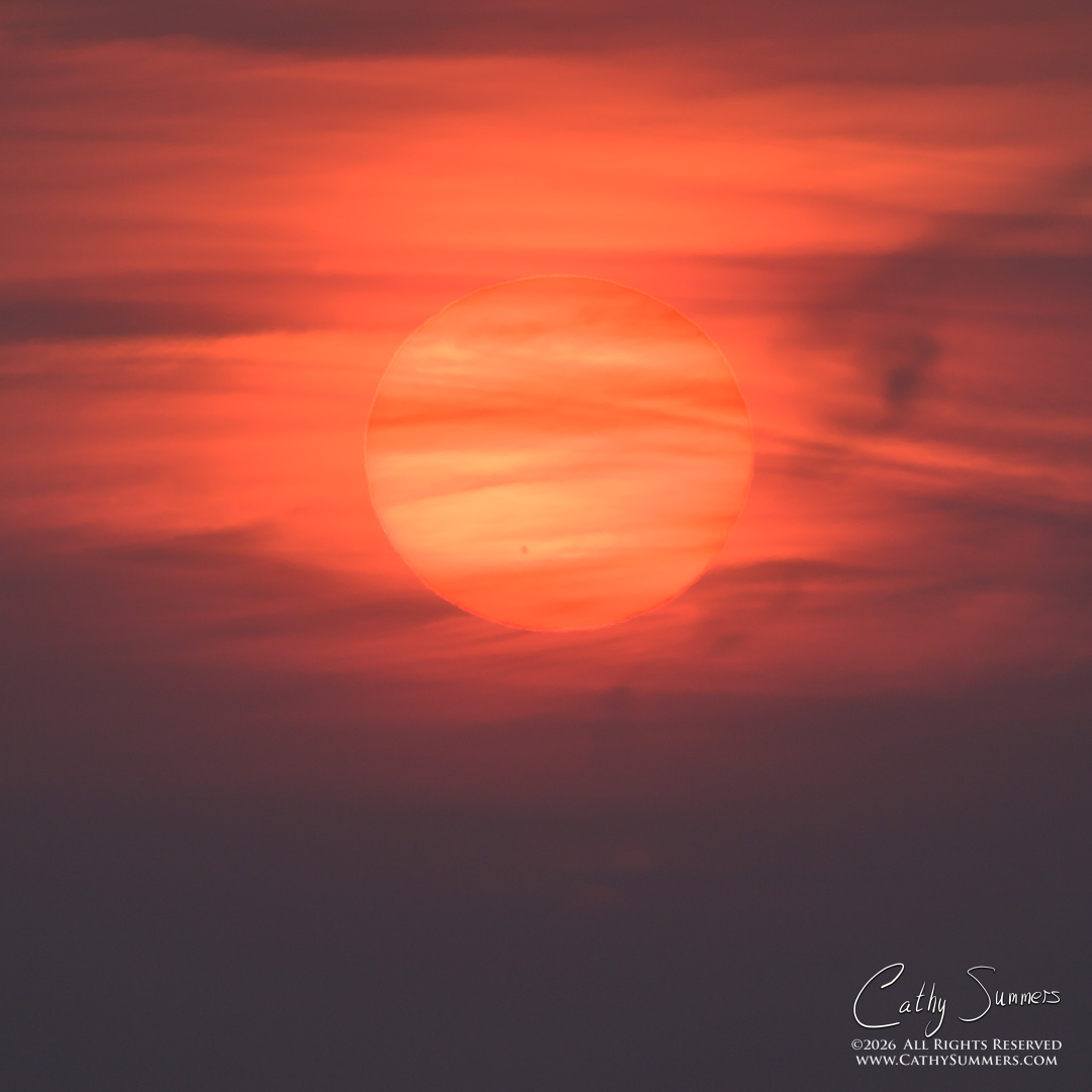 Rising Sun Through Smoke and Clouds