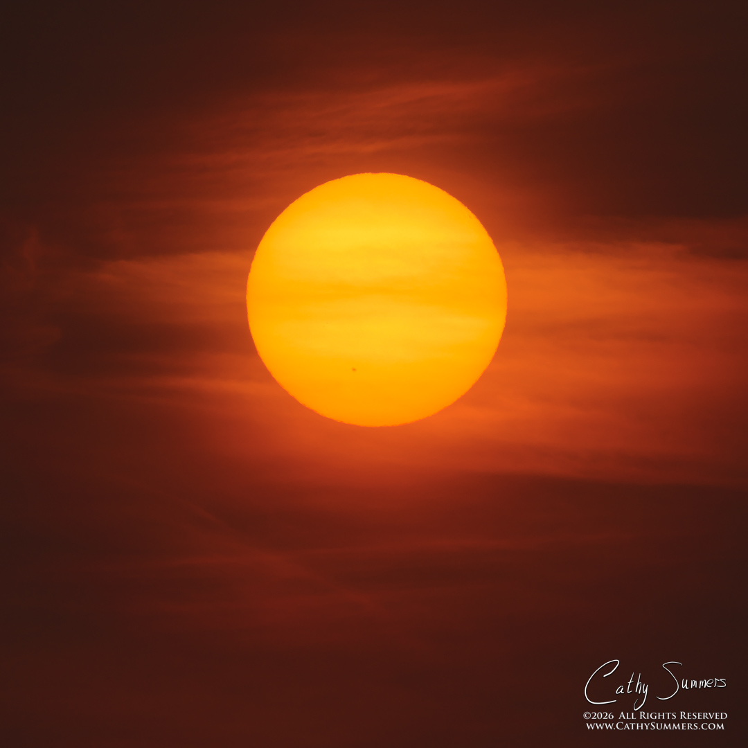 Rising Sun Through Smoke and Clouds